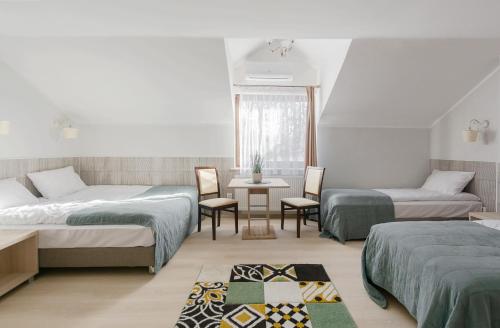 1 dormitorio con 2 camas, mesa y sillas en Pensjonat Agroturystyczny Premium Kraków Ojcowski Park Narodowy Cracovia Arabians, 