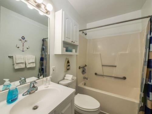 a bathroom with a sink and a toilet and a mirror at Trendy 1BD Balcony Pool Small fam or couples stay in Ocean City