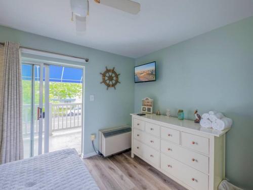 a bedroom with a bed and a dresser and a window at Trendy 1BD Balcony Pool Small fam or couples stay in Ocean City