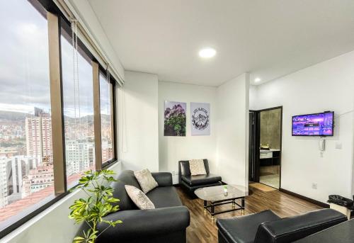 a living room with a couch and a tv at Sky Suites Sopocachi in La Paz