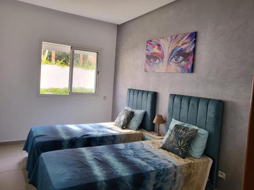 een slaapkamer met 2 bedden en een schilderij aan de muur bij Résidence les terrasses 2 in Pont Blondin