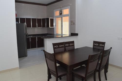 a kitchen with a dining room table and chairs at RED-36 - Al Mareekhy Villas in Salalah