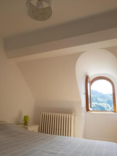 a bedroom with a bed and a window at Appartement cosy pour une pause sereine et chaleureuse in Le Mont-Dore