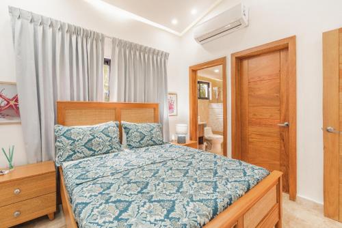 Schlafzimmer mit einem Bett mit blauer Decke in der Unterkunft Charming villa with private pool in Juan Dolio in Juan Dolio
