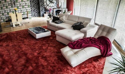 a living room with white couches and a red rug at Luxury Apartments Burgas in Burgas City