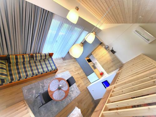 Draufsicht auf ein Wohnzimmer mit Sofa und Treppe in der Unterkunft Nemirsetos kopos in Palanga