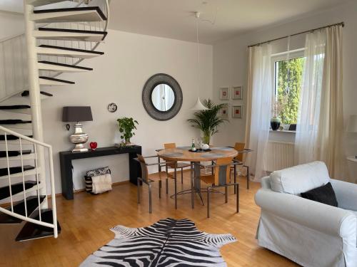 ein Wohnzimmer mit einem Tisch und einer Wendeltreppe in der Unterkunft Am Apfelbaum, ein Ferienhaus zwischen Rhein und Mosel in Kastellaun