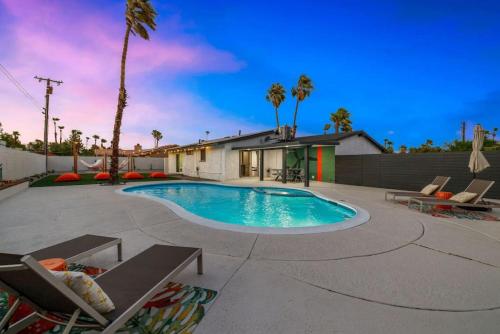 a swimming pool in a yard with palm trees at Acacia Retreat by Rather Be Properties in Palm Springs