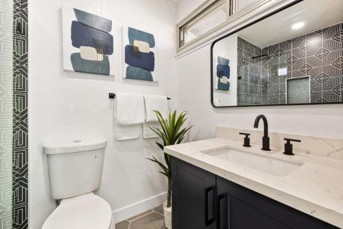 a bathroom with a toilet and a sink and a mirror at Acacia Retreat by Rather Be Properties in Palm Springs