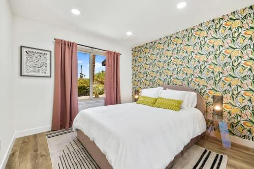 a bedroom with a large bed with a colorful wall at Acacia Retreat by Rather Be Properties in Palm Springs