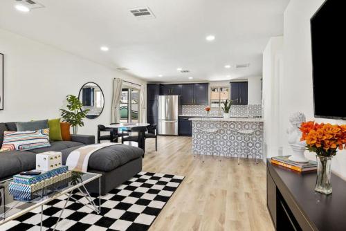 a living room with a couch and a kitchen at Acacia Retreat by Rather Be Properties in Palm Springs