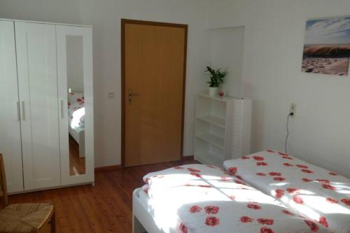 1 dormitorio con 2 camas y puerta con espejo en Urlaub in Engelswacht en Sundhagen-Niederhof