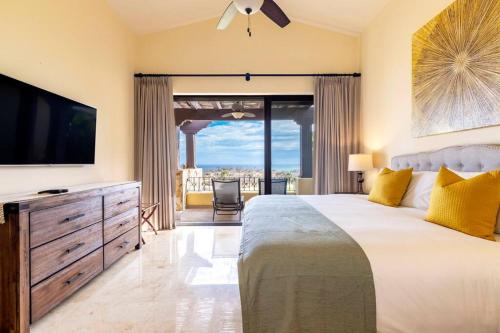a bedroom with a large bed with a flat screen tv at 3BD Golf Front Beach Club and Hot Tub in PLC in San José del Cabo