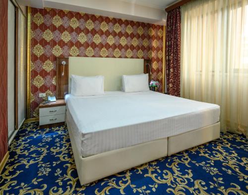 a bedroom with a large bed in a room at Royal Plaza by Stellar Hotels, Yerevan in Yerevan