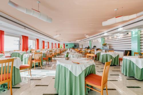 a restaurant with tables and chairs with green table cloth at Best Western Hotel La Solara in Sorrento