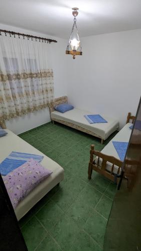 Cette chambre comprend 3 lits et un lustre. dans l'établissement Private guest-house Gutic, à Sutomore