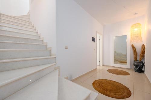 a white staircase in a white room with a rug at Villa Virginia in Ambelas