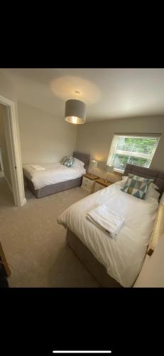 1 dormitorio con 2 camas y ventana en Kilbarth Cottage en Haverfordwest
