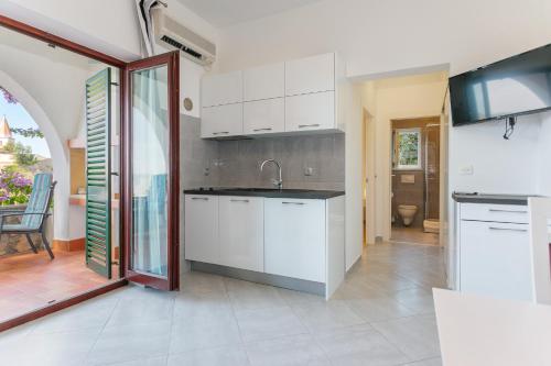 una cocina con armarios blancos y fregadero en Apartments Delfin, en Krk