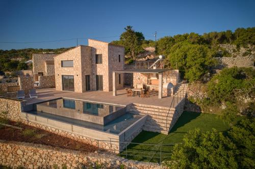 uma vista aérea de uma casa com piscina em Aroa Eco Living Experience em Volímai