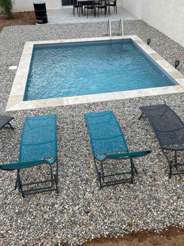 2 Stühle und ein Pool mit 2 Stühlen in der Unterkunft Vacances en Ardèche "maison pont d'arc" in Vallon-Pont-dʼArc