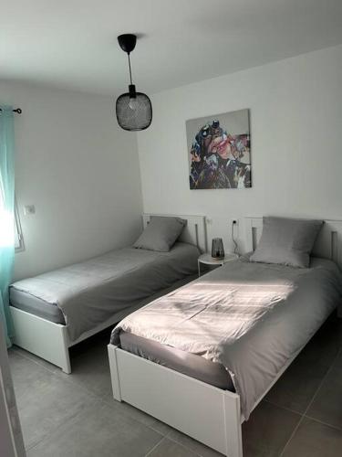 ein Schlafzimmer mit 2 Betten und einer Lampe in der Unterkunft Vacances en Ardèche "maison pont d'arc" in Vallon-Pont-dʼArc