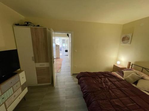 a bedroom with a bed and a television and a hallway at Apartman Stela in Nin