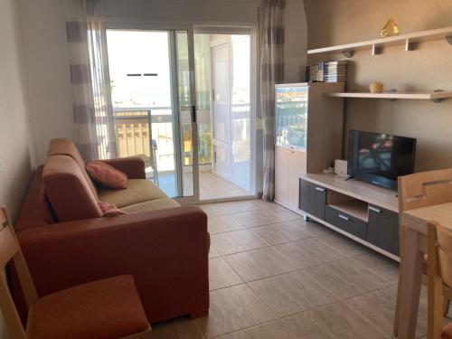 a living room with a couch and a television at APARTAMENTO PUERTO PLAYA in Villajoyosa