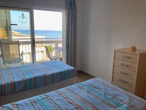 a bedroom with two beds and a view of the ocean at APARTAMENTO PUERTO PLAYA in Villajoyosa