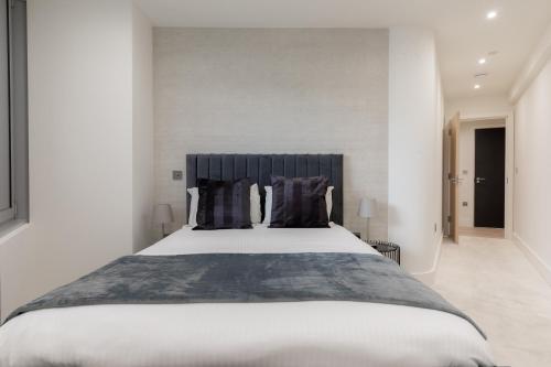 1 dormitorio con 1 cama grande con almohadas negras en StayInn Stratford, en Londres