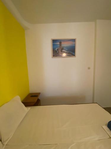 a bedroom with a bed and a picture on the wall at Yellow Beach House in Logaras