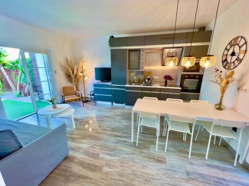 a kitchen and living room with a white table and chairs at Les Cactus Fréjus Plage in Fréjus