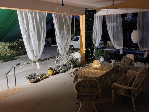 a patio with a table and chairs and curtains at Oranje Guesthouse in Itea