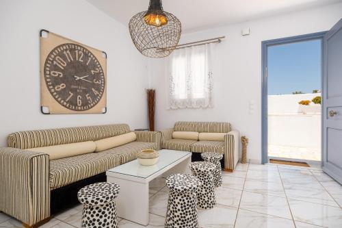 a living room with a couch and a clock on the wall at Villa Virginia in Ambelas