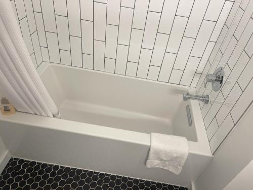 a white bath tub with a shower curtain and a towel at Walk to Downtown UT Sports Famous Dining and abundant Nightlife from this Luxury Condo w 3 restaurants in the complex in Austin