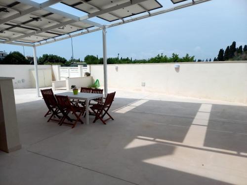 eine Terrasse mit einem Tisch und Stühlen auf dem Dach in der Unterkunft SALENTO AT HOME in Nardò