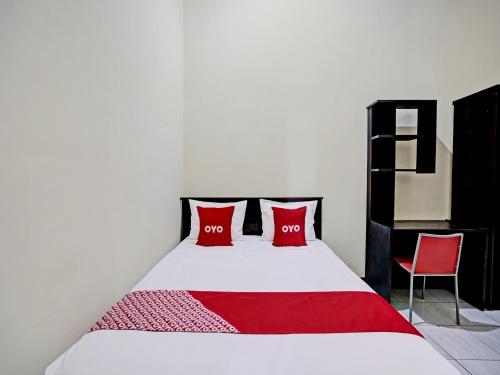 ein Schlafzimmer mit einem Bett mit zwei roten Kissen in der Unterkunft OYO Life 92773 Griya Trubus Syariah in Tuban
