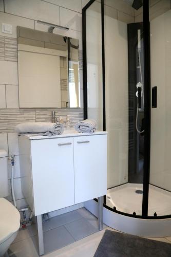 une salle de bain avec un lavabo blanc et une douche dans l'établissement MERCURE, à Saint-Quentin