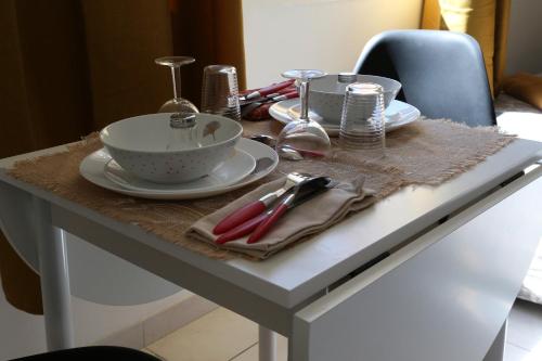 einen Tisch mit Tellern und Geschirr darüber in der Unterkunft MERCURE in Saint-Quentin