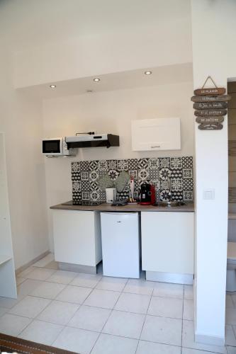 une cuisine avec des armoires blanches et un comptoir dans l'établissement MERCURE, à Saint-Quentin