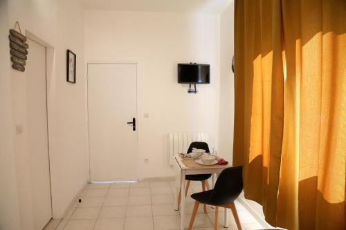 Zimmer mit einem Tisch, Stühlen und einer Tür in der Unterkunft MERCURE in Saint-Quentin