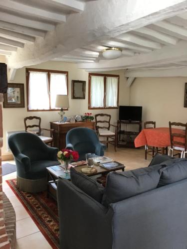 uma sala de estar com um sofá, cadeiras e uma mesa em Le Clos du Vivier em Valmont
