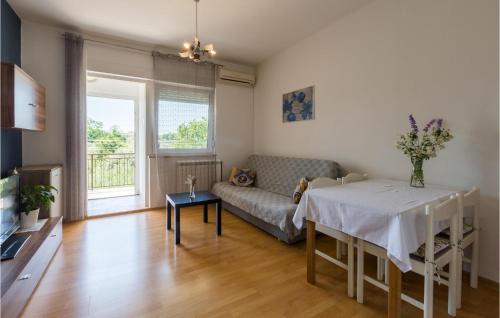 uma sala de estar com um sofá e uma mesa em Stunning Apartment In Umag With 2 Bedrooms And Wifi em Umag