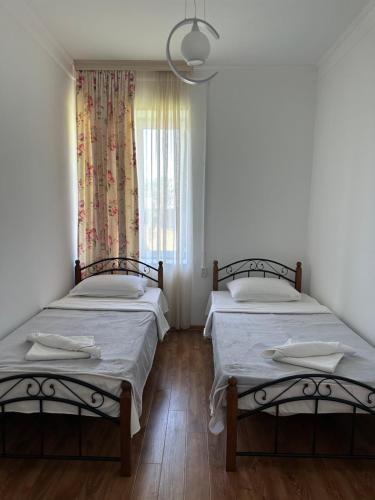 Duas camas num quarto com uma janela em Leila's Guest House em Joqolo