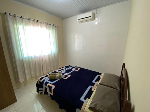 - une chambre dotée d'un lit avec une couverture bleue et blanche dans l'établissement 03 - Casa praia pinheira perto da guarda, à Palhoça