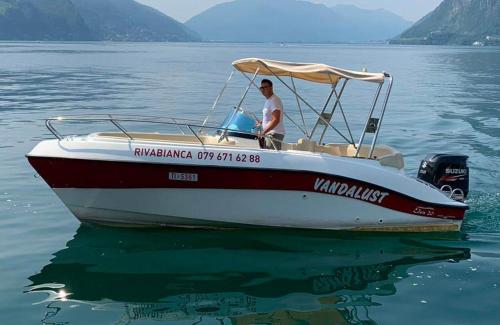a man sitting on a boat in the water at Violet Suite 5 Lugano City for 4 Guest -By EasyLife Swiss in Lugano