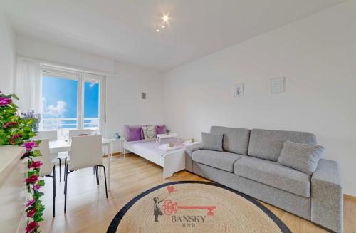 a living room with a couch and a dining room at Violet Suite 5 Lugano City for 4 Guest -By EasyLife Swiss in Lugano