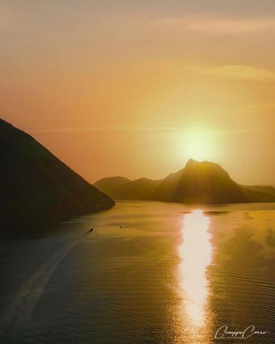 a sunset over a body of water with a mountain at Violet Suite 5 Lugano City for 4 Guest -By EasyLife Swiss in Lugano