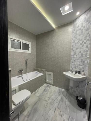 La salle de bains est pourvue d'une baignoire, de toilettes et d'un lavabo. dans l'établissement Master Suite in Bellavista Andalucia with Pool and Beach, à Al Matlīn