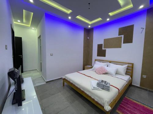 a bedroom with a bed with a purple wall at Master Suite in Bellavista Andalucia with Pool and Beach in Al Matlīn